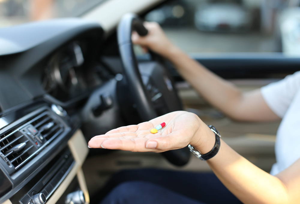 Woman driving Car and taking medication