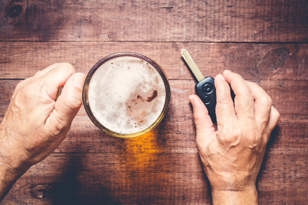 Man holding beer and car keys