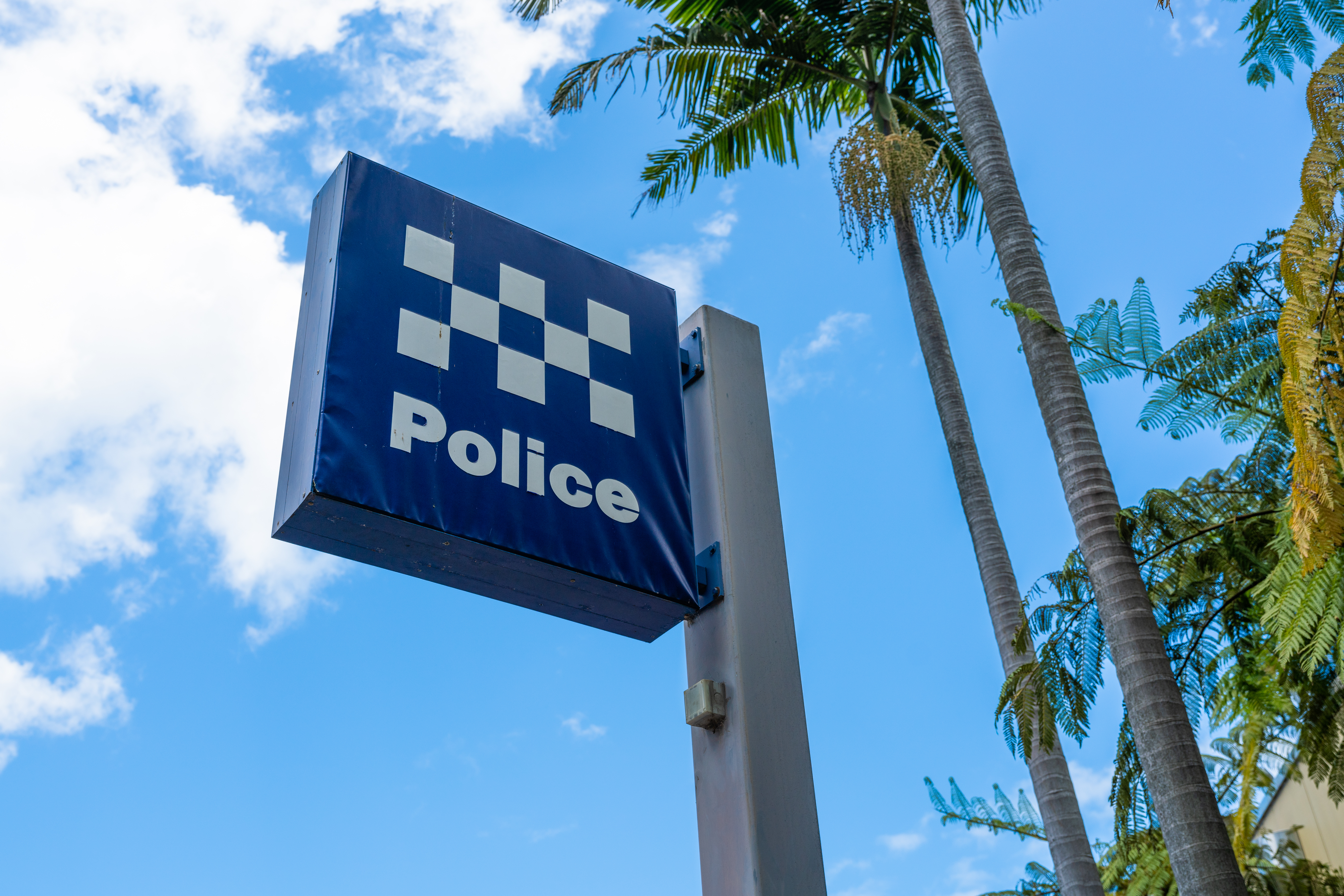 NSW Police sign next to trees outside.