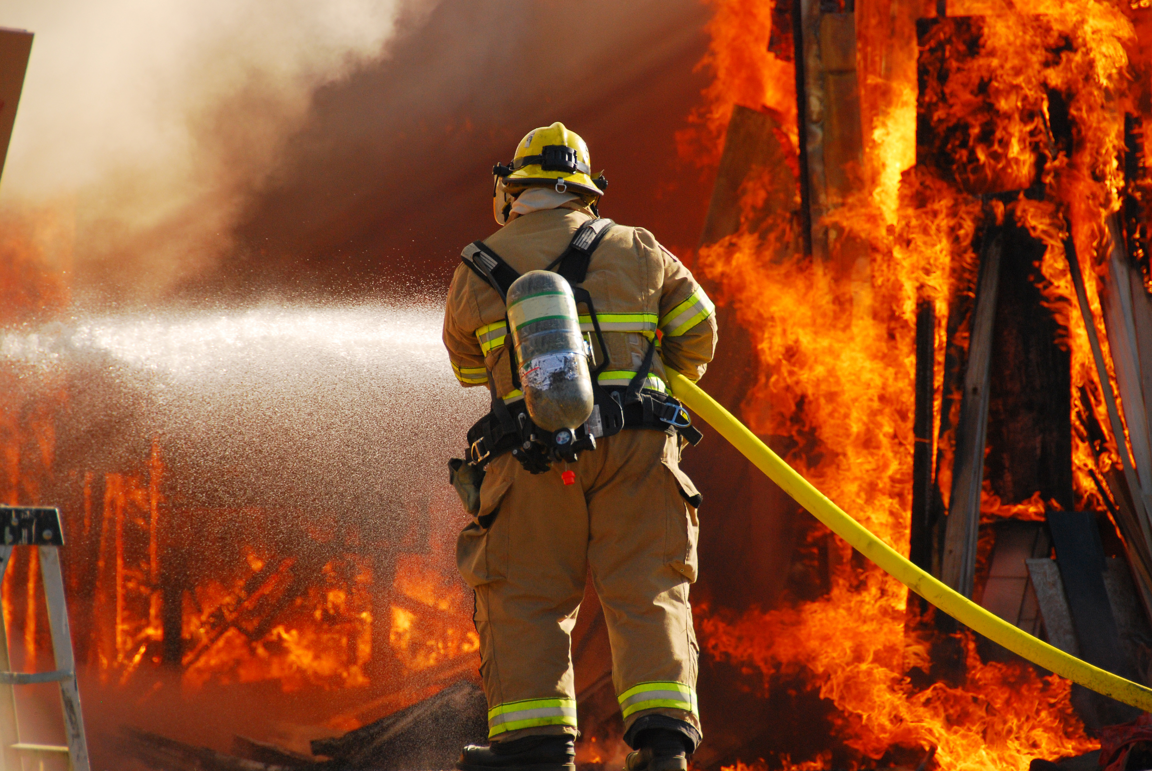Firefighter infront of a building on fire