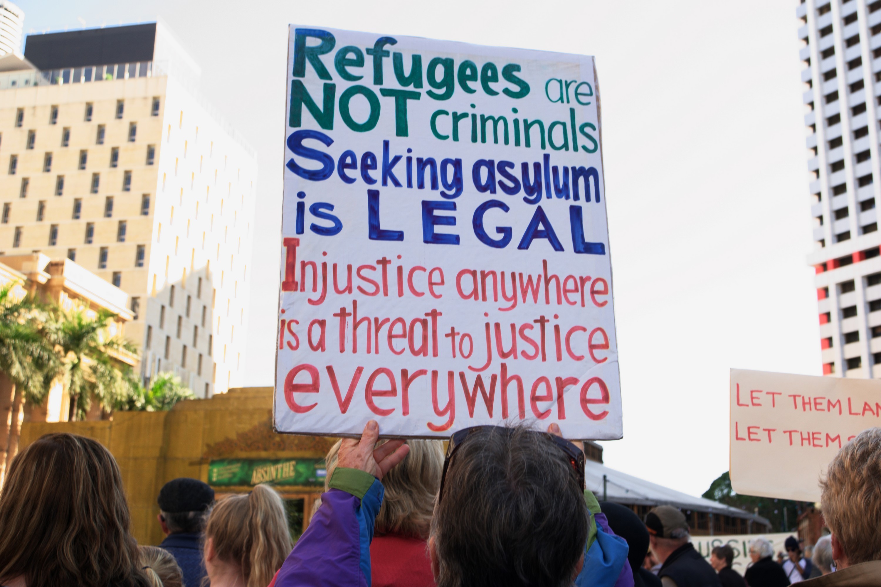 Refugee protest sign amongst crowd